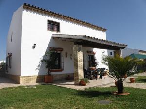 une petite maison blanche avec une table en face dans l'établissement Casas Elena-Conil, à Conil de la Frontera