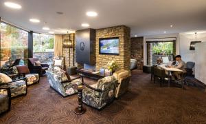 a man sitting at a table in a living room at Queenstown Park Boutique Hotel in Queenstown