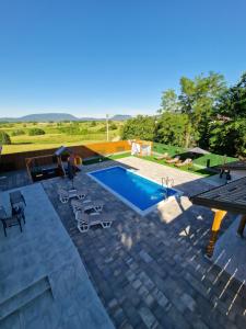 a swimming pool with chairs and a table next to it at Villa Crystal in Bihać