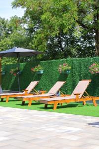 two lounge chairs and an umbrella in a park at Villa Crystal in Bihać