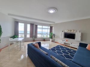 a living room with a blue couch and a tv at Beach View Apartment (Boulevard Mohammed VI) in Tangier