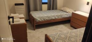 a small bedroom with a bed and a dresser at Complejo las Catalinas Dto 2 A in Puerto Madryn