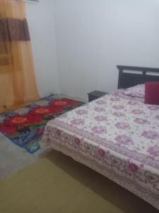 a bed with a quilt on it in a room at Chambre hostel Assif in Marrakech