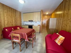 a kitchen with a table and two red chairs and a kitchen with at Berto’s House in Montoso