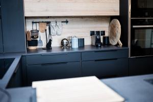 a kitchen with black cabinets and a counter top at Maison Flo in Honfleur