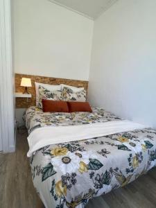 ein Schlafzimmer mit einem Bett mit geblümter Bettdecke in der Unterkunft Le Tropico - Clim - Terrasse - Proche Polygone in Béziers