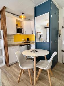 eine Küche mit einem Tisch und 2 Stühlen in der Unterkunft Le Tropico - Clim - Terrasse - Proche Polygone in Béziers + 9 Fotos