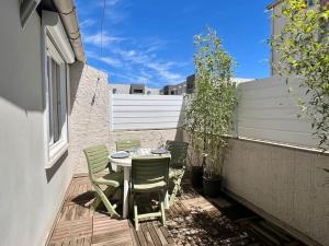 eine Terrasse mit Tisch und Stühlen auf einem Balkon in der Unterkunft Le Tropico - Clim - Terrasse - Proche Polygone in Béziers