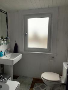 Un baño con inodoro, lavabo y ventana. en Twin room close to Royal Troon free parking, en Irvine