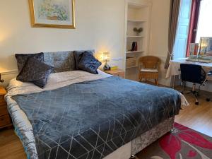 Un dormitorio con una cama con un edredón azul. en Twin room close to Royal Troon free parking, en Irvine