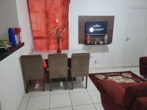 a dining room with a table and chairs and a television at Ap mega Space, Arena GRAN HaLL, café 3 corações, 20min ct Galo, CAMPO IMPERIAL,Aquabeat, 30min Aeroporto in Santa Luzia