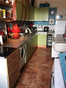 cocina con armarios verdes y lavadora en Twin room close to Royal Troon free parking, en Irvine