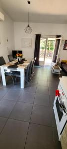a living room with a table and chairs on a tile floor at villa Paty in Bonifacio