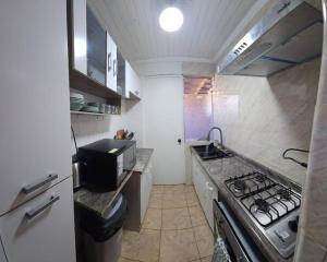 a small kitchen with a stove and a sink at Casa cómoda y funcional in Peumo