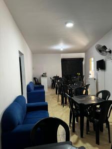 a waiting room with tables and blue couches and chairs at Hostel Del Sol in Cabo Frio +29 photos