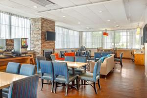 a waiting room with tables and blue chairs at Best Western Hartford Hotel and Suites in Hartford