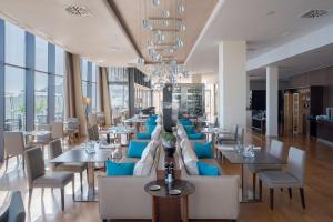 a restaurant with blue chairs and tables and windows at Radisson Blu Resort Gran Canaria in La Playa de Arguineguín