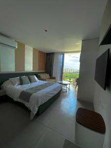 a bedroom with a large bed and a balcony at Suite con excelente vista al mar in Santa Marta