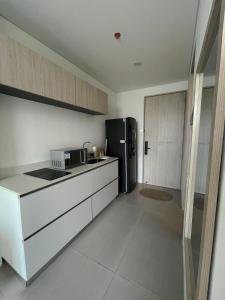 a kitchen with a black refrigerator and white cabinets at Suite con excelente vista al mar in Santa Marta