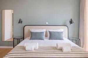 Un dormitorio con una gran cama blanca con dos almohadas. en VC Heritage Ribeira Porto, en Oporto