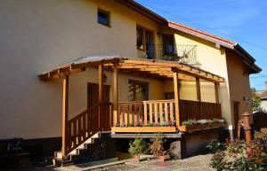 ein Haus mit einer Holzterrasse und einem Balkon in der Unterkunft Guest House Penzión Milka in Smižany