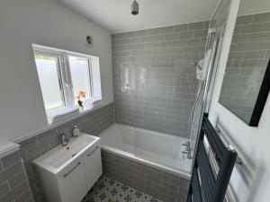 a bathroom with a white tub and a sink at Maya's Lodge in Dublin
