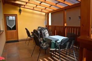 a room with a table and chairs and a wooden ceiling at Guest House Penzión Milka in Smižany