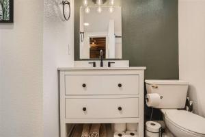 a bathroom with a sink and a toilet and a mirror at Serene, Spacious Home in Quiet Neighborhood with Fenced Yard in Aurora