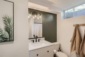a bathroom with a sink and a toilet and a mirror at Serene, Spacious Home in Quiet Neighborhood with Fenced Yard in Aurora