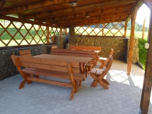 uma mesa de madeira e cadeiras sentadas sob um pavilhão em Chata Jílové em Jílové
