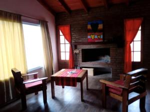 a living room with a table and a fireplace at Nuestro Chalet in La Falda