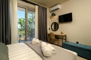 a hotel room with a bed with towels on it at CorfuVille Luxury Villas in Danilia +282 photos