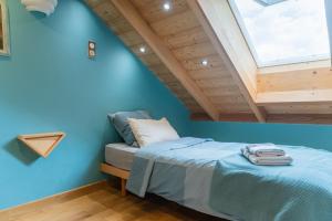 コルマールにあるColmar Friends and Familly guest home - ALL INCLUSIVE - COLMAR Gare - Jardin - Combles et Vousの青い壁と天窓付きのベッドのある寝室