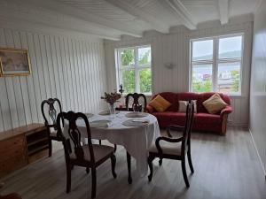 a living room with a table and a red couch at George&K Apartament in Larvik