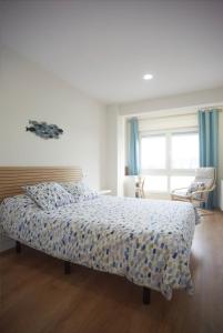 1 dormitorio con cama con edredón en Sailor Home Apartamento con vistas al puerto de Santander, en Santander