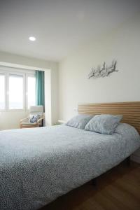 Un dormitorio con una cama grande y una silla. en Sailor Home Apartamento con vistas al puerto de Santander, en Santander