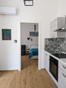 Il comprend une cuisine aux murs blancs et une chambre avec un lit. dans l'établissement I Sogni Di Aretusa, à Syracuse