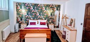 een slaapkamer met een bed met een bloemenbehang bij Burton Stone Inn in York