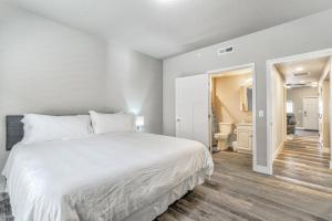 une chambre avec un grand lit blanc et une salle de bain dans l'établissement New Lower Condo-mins to downtown-Pet Friendly, à Colorado Springs