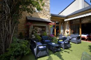 an outdoor patio with chairs and a fireplace at Logis Hotel Restaurant Planes in Saillagouse