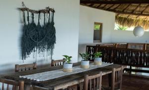 a dining room with a wooden table with potted plants at Casa Manzanillo - Ocean Room - Ocean View Room at Exceptional Beach Front Location in Troncones