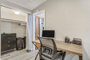 einen Schreibtisch mit einem Computer und einem Stuhl in einem Zimmer in der Unterkunft Walkable to downtown restaurants & bars-Fire Pit in Colorado Springs