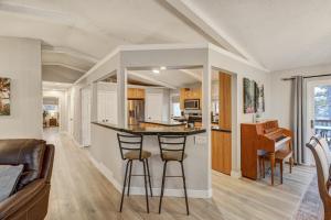 a kitchen and living room with a bar with stools at El Dorado- Cozy Retreat-Hot Tub-Upper Level in Pikeview