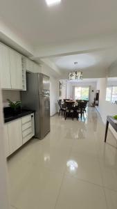 a large kitchen and dining room with a dining table at Apto Lírio da Paz- 3 Quartos com sacadas,espaçoso e de frente para avenida principal! in Piratuba