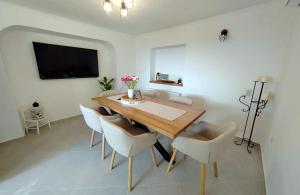 ein Esszimmer mit einem Holztisch und Stühlen in der Unterkunft Holiday house with a parking space Mundanije, Rab - 23396 in Rab