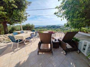 eine Terrasse mit einem Tisch und Stühlen sowie Aussicht in der Unterkunft Holiday house with a parking space Mundanije, Rab - 23396 in Rab + 9 Fotos