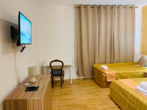 a room with a bed and a desk and a television at Venice Villa House in Mestre