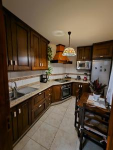 a kitchen with wooden cabinets and a sink and a table at El Mirador Vistas muy bonitas in Breña Baja