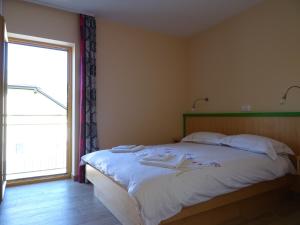 a bedroom with a bed and a large window at Hotel Vegov Hram in Dol pri Ljubljani