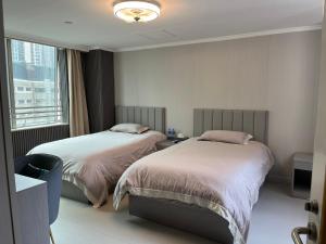 a hotel room with two beds and a window at 皇后超級管家 in Hong Kong